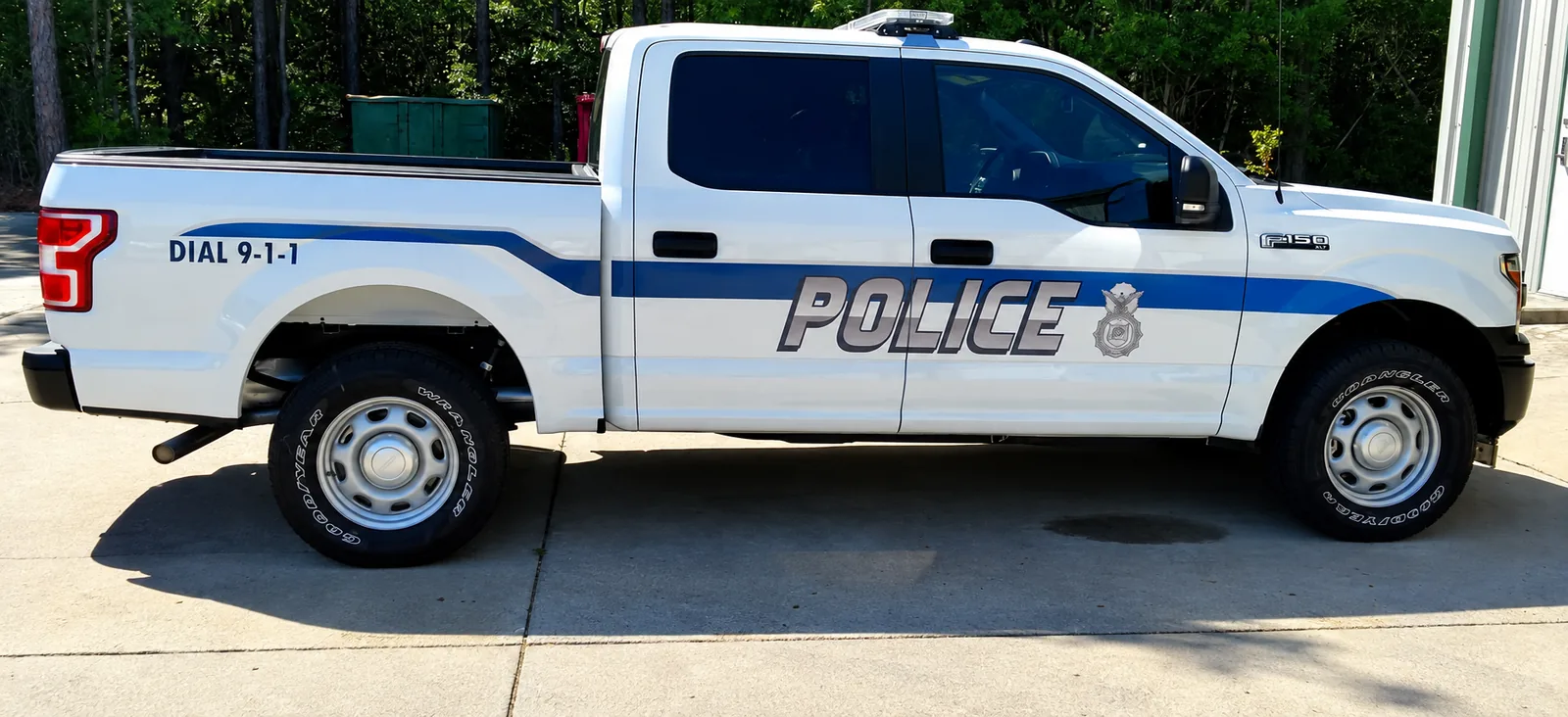 Police pickup truck with blue stripe and department graphics