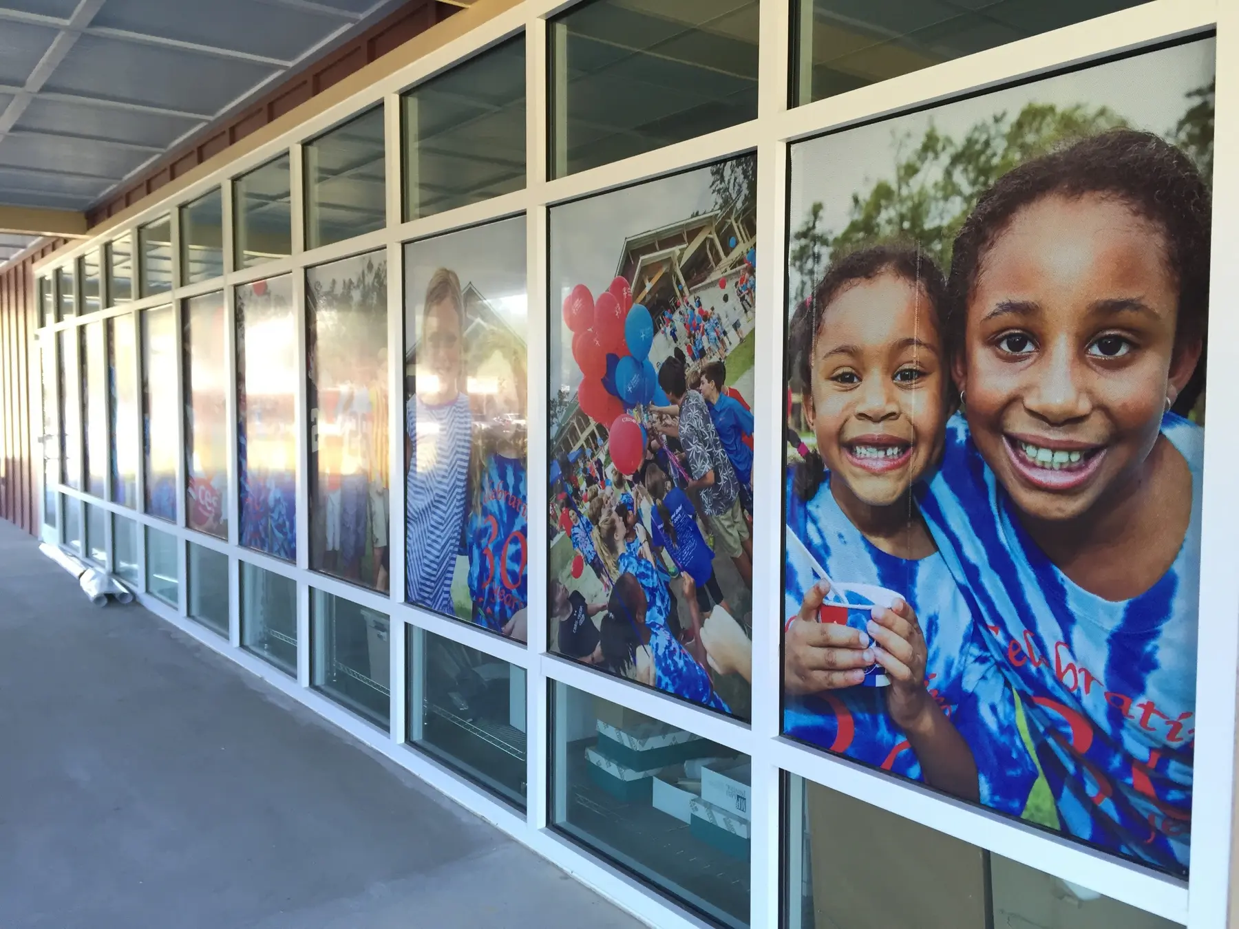 School campus window graphics featuring students and community events