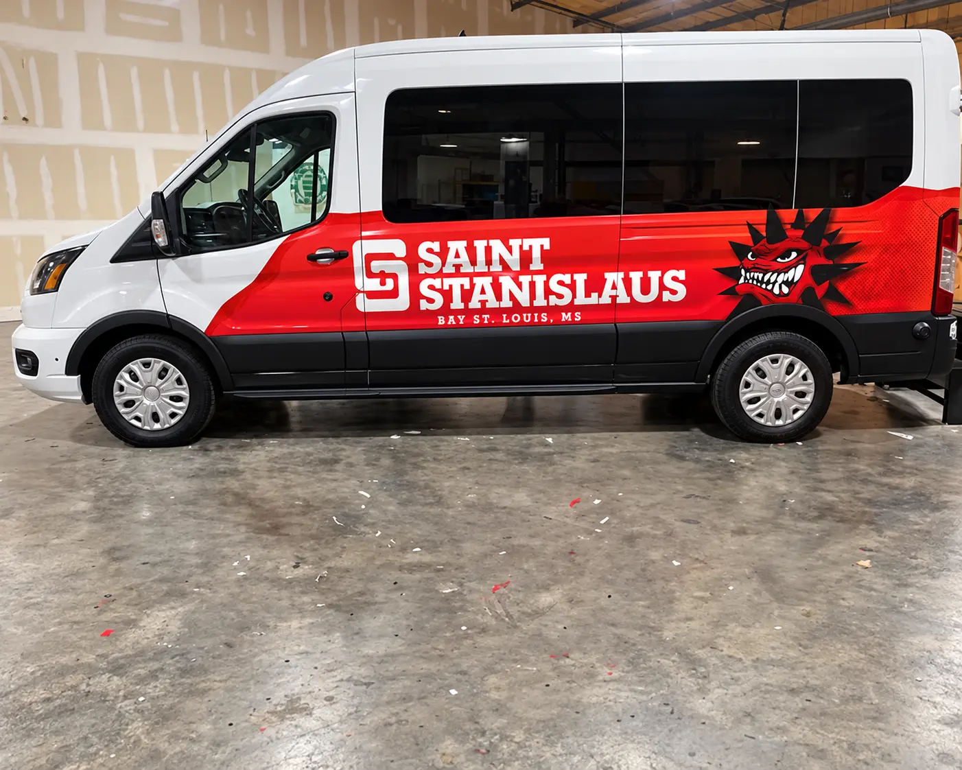 Saint Stanislaus College passenger van partial wrap in red, black, and white