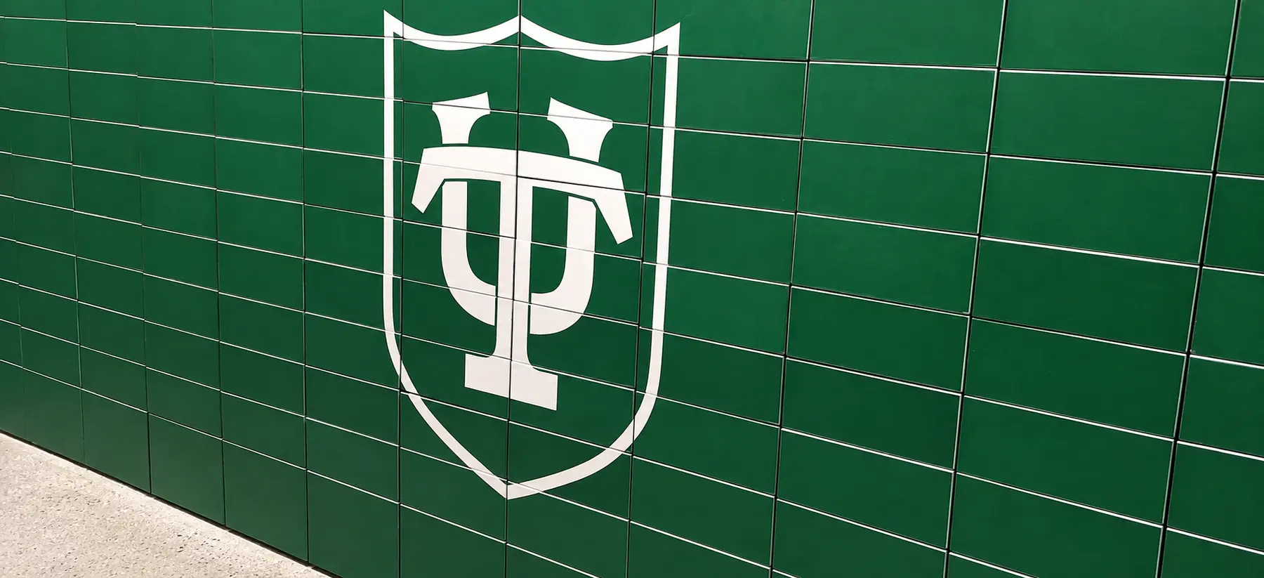 Tulane University green tiled wall graphics with white TU shield